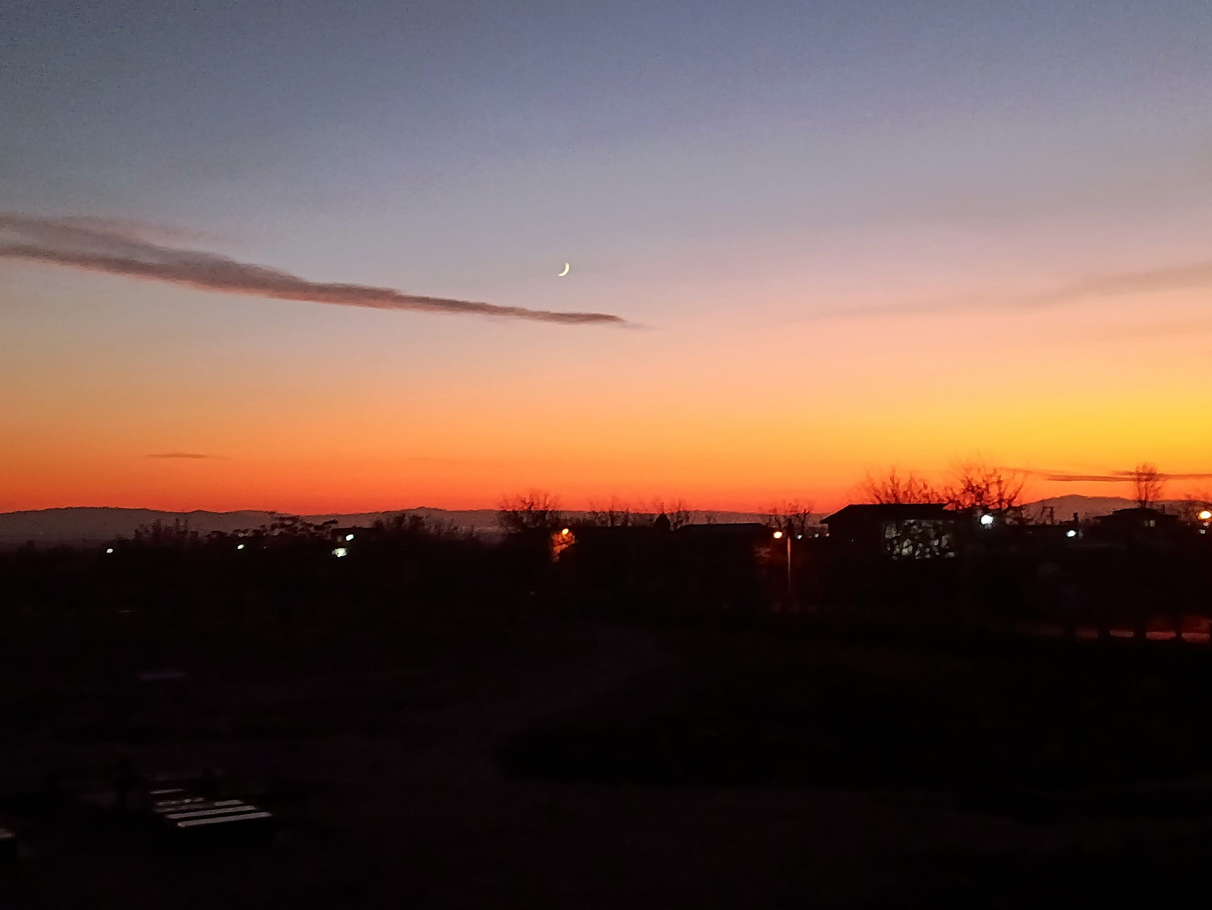 Crescent moon and vivid orange twilight sky